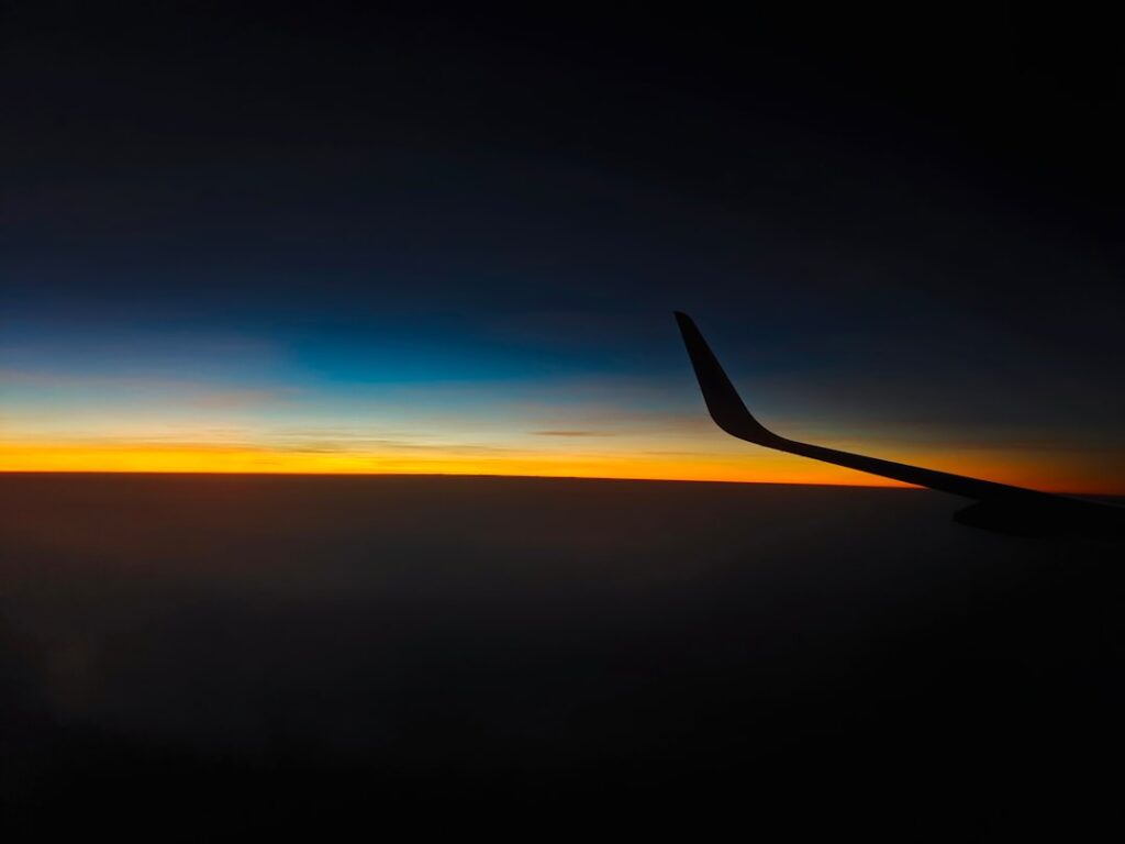 airplane window view sunrise over clouds